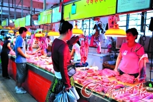 　　市民在市场挑选猪肉。　　王燕 摄